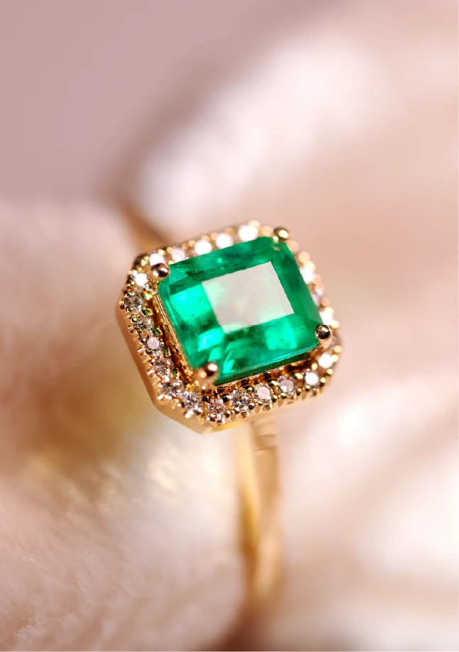 Anillo de oro con esmeralda cuadrada rodeada de diamantes