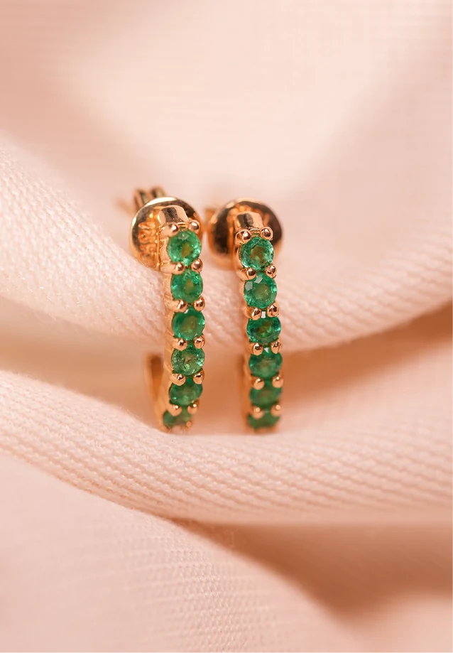 Aretes de oro tipo huggie con esmeraldas