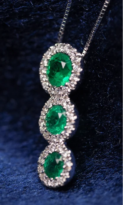 Dije de tres esmeraldas sobre terciopelo azul